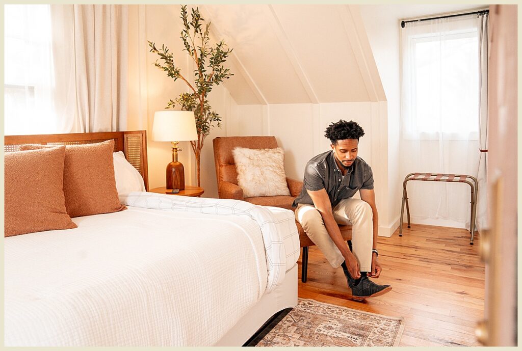 Peri Social hotel travel photography featuring a man tying his shoes in the guest suite of the hotel.