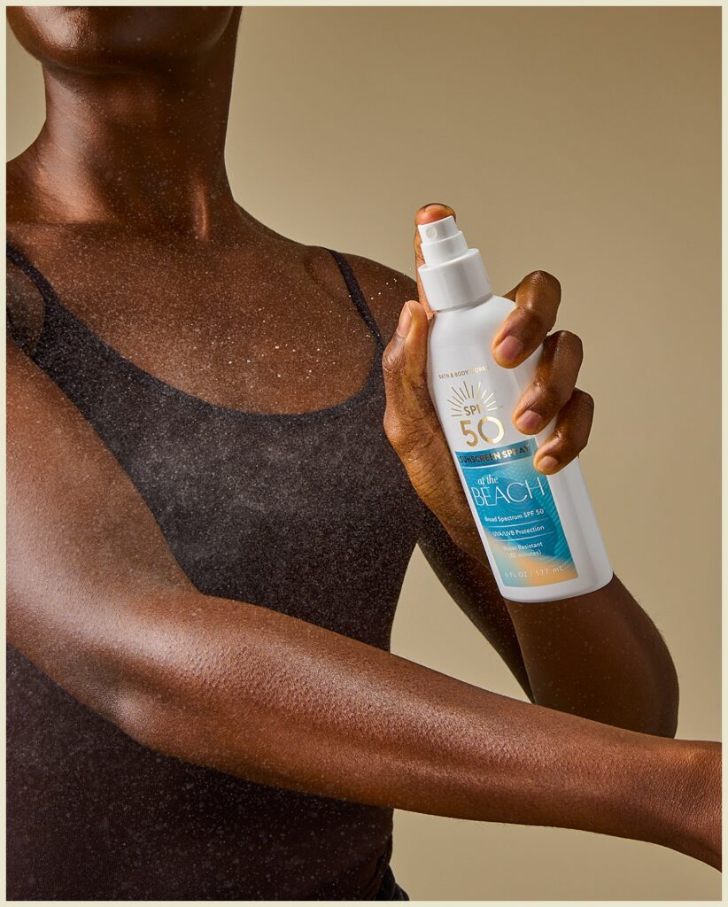E commerce product photography featuring a model spraying SPF sunscreen on her arm in Columbus, Ohio.